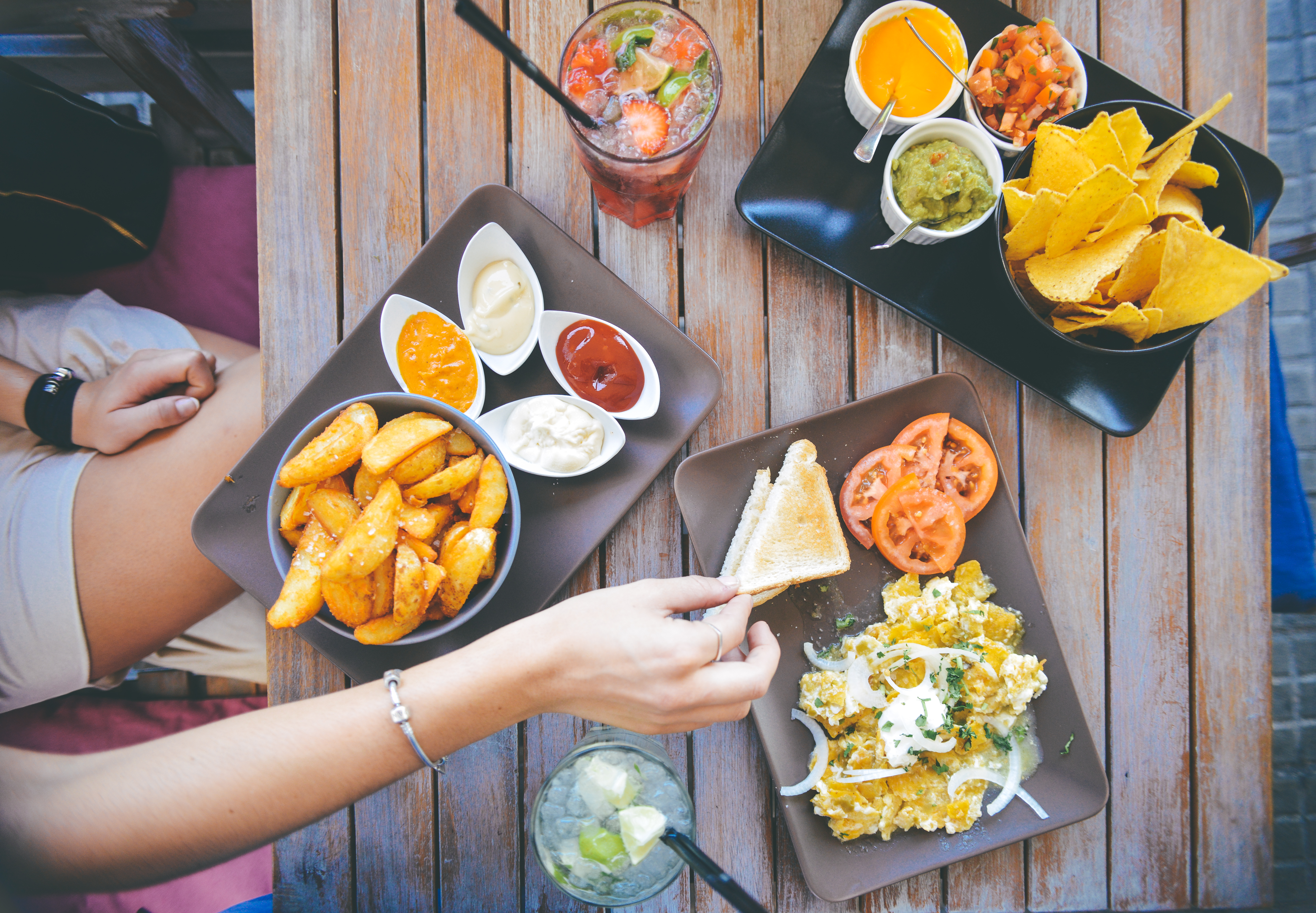 There are many reasons you aren't losing weight. One of them can be rewarding yourself with food. Here is large assortment of food with fries, chips and drinks.